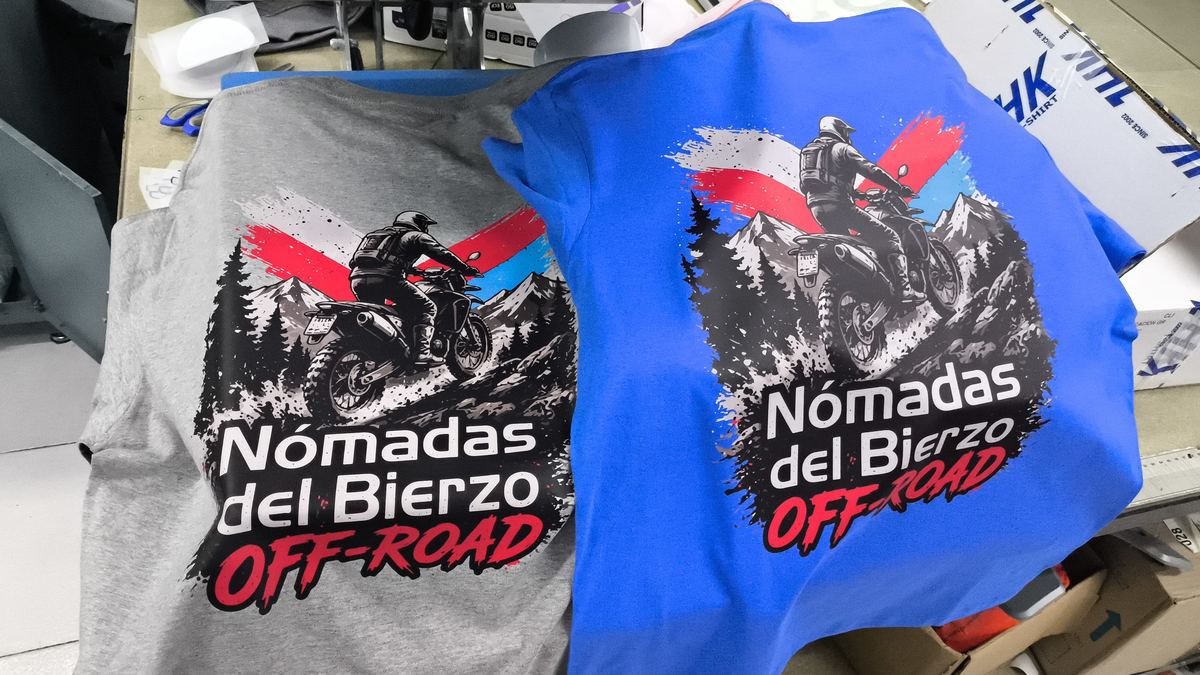 Sudadera y camiseta grises con la ilustración off-road de Nómadas del Bierzo impresa a gran tamaño en la espalda mediante DTF.